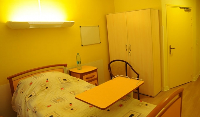 chambre jaune avec un lit et une armoir